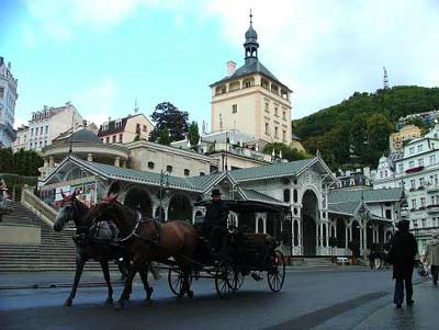 Horse drawn cariage passing the colonnades in Karlovy Vary